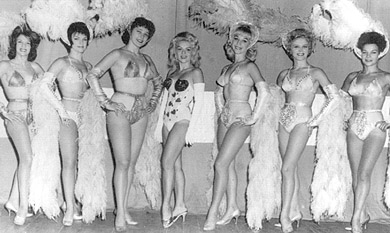 Headline stripper Val Valentine poses in the center of the chorus line with Gene Vaughan's 1963 revue on Olson shows. (Left to right) Rae and Anita Keppo, Cindy, Val, Lannie, Marti Calvert, and Elda Bohn.