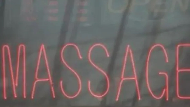 A sign advertises the services of a massage parlour. Those businesses are currently shuttered by the pandemic...