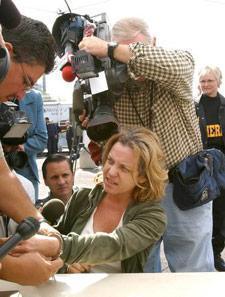 The media swarms around Becky Jane Kearns at a processing center set up in the parking lot at Park Central Mall Thursday morning. Dozens of suspected prostitutes and their customers were arrested in a Valleywide roundup.