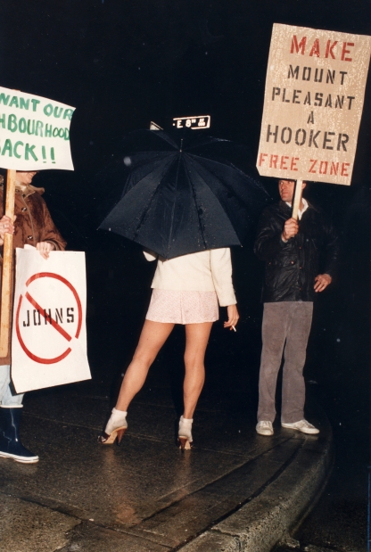 Prostitute confronts man with 'Make Mount Pleasant a Hooker Free Zone' sign. May 1986. Peter Battistoni, Vancouver Sun