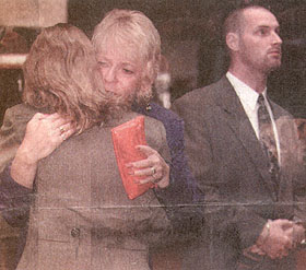 FAMILIES OFFER COMFORT: Janet Fillon (mother of victim Misty Cockerill, back to camera) embraces wife of Grant Driver, father of the killer Terry, as the convicted man's brother Donald Driver stands near by.