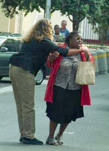 Anguished domestic worker arrives at the crime scene and tries to go see her boss who was murdered, but is lead away and comforted by this police officer. Photo: Die Burger